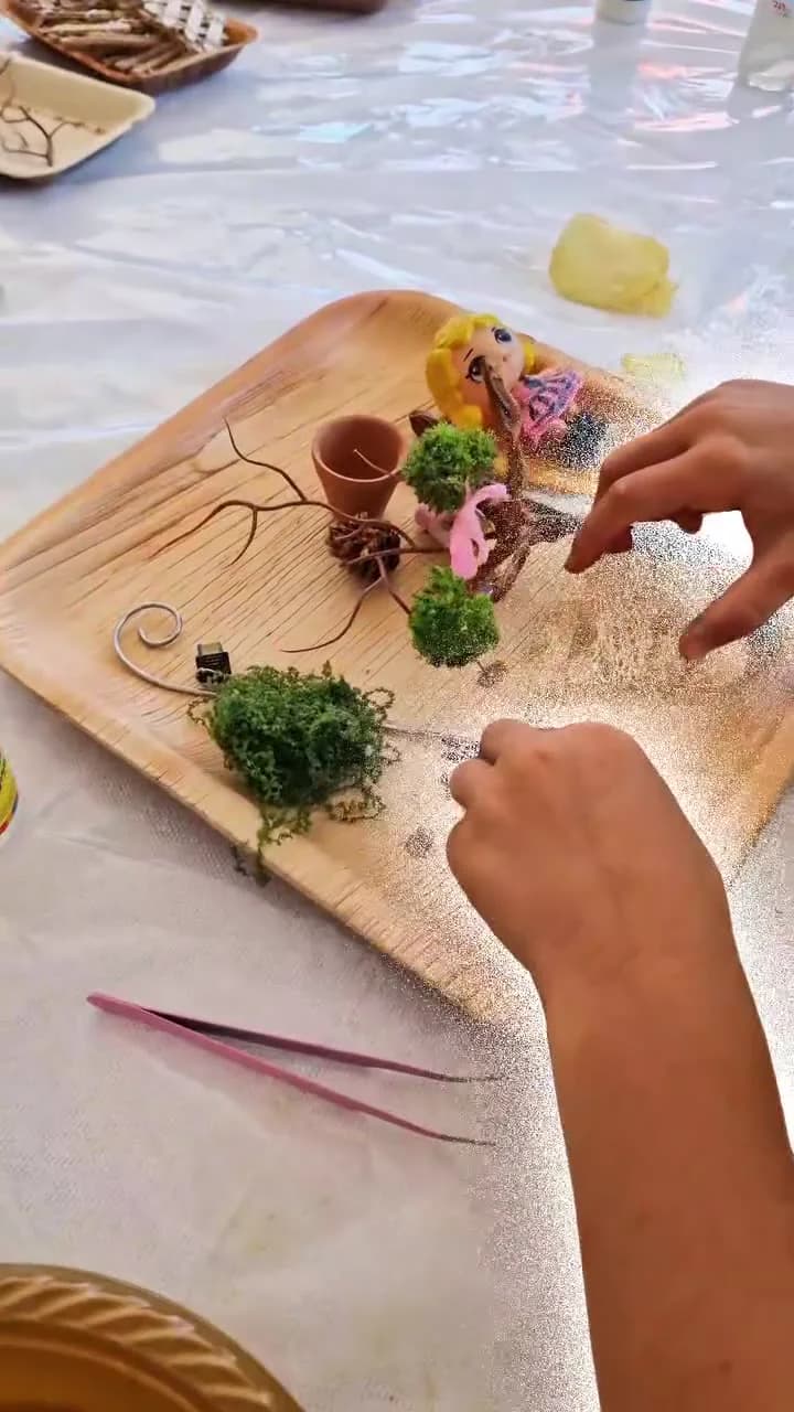 ידיים מסדרות צמחייה ואביזרים על במת עץ קטנה